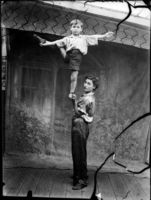 girl holding brother aloft