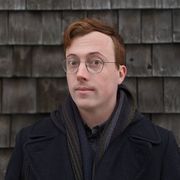 Photo of writer Peter Counter standing in front of a stone wall, wearing a dark wool jacket. Photo credit Emma Dawn Allain.