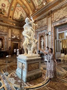 A sculpture at the Borghese Gallery, Rome with a tour guide in front.