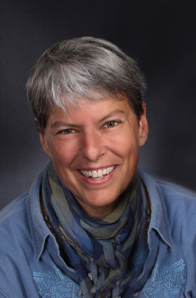 Dian Day author photo. A smiling person with short gray hair wearing a blue shirt and a multicolored scarf, posed against a dark background. Dian Day author photo. A smiling person with short gray hair wearing a blue shirt and a multicolored scarf, posed against a dark background.