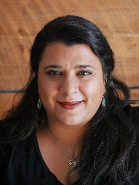Portrait of author Élyssa Marcoux-Bissoondath smiling at the camera, with long dark hair and a warm wooden background. Portrait of author Élyssa Marcoux-Bissoondath smiling at the camera, with long dark hair and a warm wooden background.