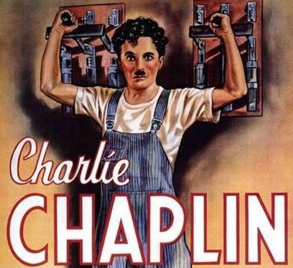 Detail from the original theatrical poster for Modern Times (1936). Charlie Chaplin's Little Tramp character wears blue overalls and has his hands on two heavy industrial switches behind him.