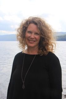 Portrait of author Tanya Bellehumeur-Allatt smiling outdoors in front of a lake, with mountains and a cloudy sky in the background. Portrait of author Tanya Bellehumeur-Allatt smiling outdoors in front of a lake, with mountains and a cloudy sky in the background.