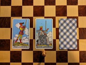 A three-card tarot spread. Only the first card is the Page of Swords. The second card is the Queen of Swords. The third card is not yet revealed.