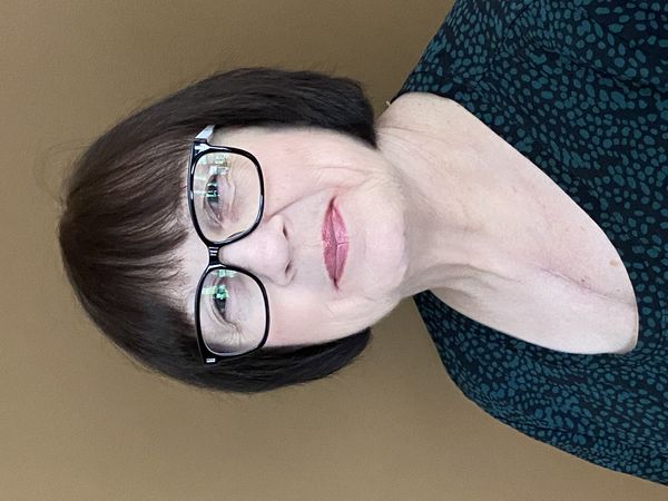 Author photo of Valerie Sherrard. She faces the camera directly with a calm, approachable expression. She has a dark bob haircut with bangs and wears black-framed rectangular glasses. Her makeup includes a soft rose lipstick. She's dressed in a teal top with a subtle dark pattern. The background is a warm neutral beige, and the lighting is even and natural, creating a professional yet personable portrait. Photo credit: Brent Sherrard. Author photo of Valerie Sherrard. She faces the camera directly with a calm, approachable expression. She has a dark bob haircut with bangs and wears black-framed rectangular glasses. Her makeup includes a soft rose lipstick. She's dressed in a teal top with a subtle dark pattern. The background is a warm neutral beige, and the lighting is even and natural, creating a professional yet personable portrait. Photo credit: Brent Sherrard.