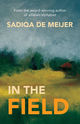 Book cover of In the Field by Sadiqa de Meijer. The cover features an impressionistic painting of a landscape with green and yellow fields under a cloudy blue-gray sky. The author’s name appears in white text at the top, and the title “IN THE FIELD” is in bold yellow and white text at the bottom.