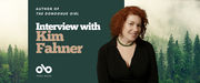 Interview with Kim Fahner, author of The Donoghue Girl banner. Background image of misty northern pine forest. Solid green section to centre left with text and Open Book logo overlaid. Author photo to centre right, image of young woman with curly red hair and black blouse, looking out thoughtfully with head slightly tilted to the left.