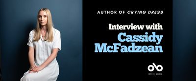 Interview with Cassidy McFadzean banner. Image of young woman with long hair and long white summer dress sitting in chair with hands in lap against a textured blue background. To the right a solid block of dark blue with text overlaid and the Open Book logo.