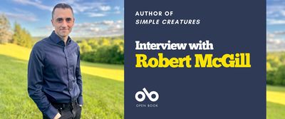 Interview with Robert McGill, author of Simple Creatures (Coach House Books) banner. Background image of sunny, rolling parkland with trees in distance. Author standing in foreground, smiling slightly with hair combed back nearly, wearing button up shirt and dark jeans with his hands in pockets. To centre right a solid blue section with text and Open Book logo overlaid.