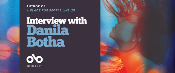 Book banner featuring text that reads “Author of A Place for People Like Us — Interview with Danila Botha.” The left side has a dark background with light blue and white text and the Open Book logo. The right side shows a blurred, colorful image of a person with long hair, head tilted back, surrounded by red and blue light effects.