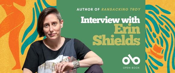 A promotional banner featuring playwright Erin Shields. She sits facing the camera, wearing a black shirt with abstract patterns and a silver cuff bracelet, against a vibrant background of abstract orange, yellow, and blue shapes. On the right side of the image, white and green text reads: "Author of Ransacking Troy — Interview with Erin Shields." The Open Book logo appears at the bottom with the text "Open Book" below it. The background includes stylized silhouettes and organic wave-like patterns.