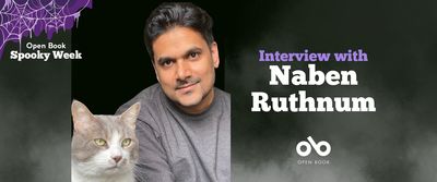 banner image with photo of author Naben Ruthnum, pictured with his light-coloured cat, and text reading Interview with Naben Ruthnum. Open Book Spooky week logo in top left corner, Open Book logo centred below text