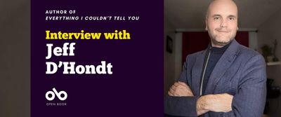 Interview with Jeff D'Hondt. Text over dark blue background with Open Book logo below, on left hand side of banner. To the right, the author standing in a living room wearing a suit with his arms crossed.