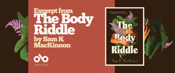 Promotional banner for The Body Riddle by Sam K. MacKinnon. The design features a horizontal layout with a warm terracotta-red central panel flanked by dark brown sections. On the left, large cream-colored serif type reads "Excerpt from The Body Riddle by Sam K MacKinnon" with the Open Book logo and text beneath. Decorative green tropical leaves and pink-purple fern fronds frame the left and right edges, echoing the book cover's botanical motif. On the right side, the book cover is displayed in a white-bordered frame, showing the signature crossed arms, foliage, and bold title treatment. The banner balances promotional text with visual branding, maintaining the book's organic, introspective aesthetic while clearly identifying the publisher and content type.