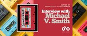 Book banner for Soundtrack: A Lyric Memoir by Michael V. Smith. On the left, the book cover features a red cassette tape with a white label, rainbow stripes, and handwritten text. The background shows colorful cassette tapes in yellow, blue, pink, and black. On the right, against a red panel, large white text reads “Interview with Michael V. Smith,” with smaller text above: “Author of Soundtrack: A Lyric Memoir.” The Open Book logo appears at the bottom.